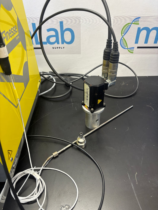 Technical setup with cables and equipment on a black surface, featuring a visible brand logo.