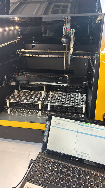 Technical setup with a computer monitor, keyboard, and various cables on a yellow surface.
