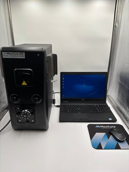MaxCyte STX Scalable Transfection System placed next to a laptop on a white bench, with a blurred background.