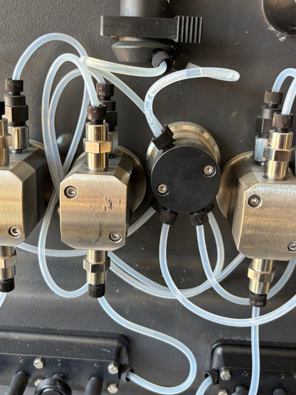 Close-up of a mechanical device with metal components and clear tubing.
