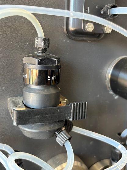 Close-up of a mechanical component with tubing on a dark background