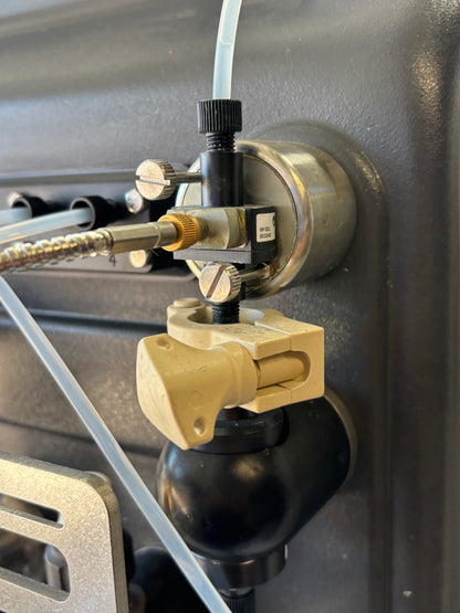 Close-up of a mechanical valve with hoses on a metallic surface