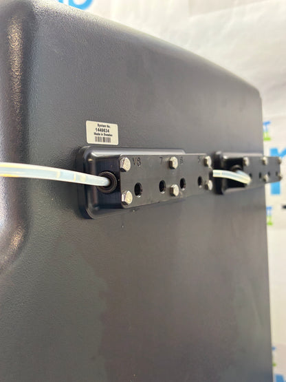 Black electronic device with a cable plugged into it on a white background