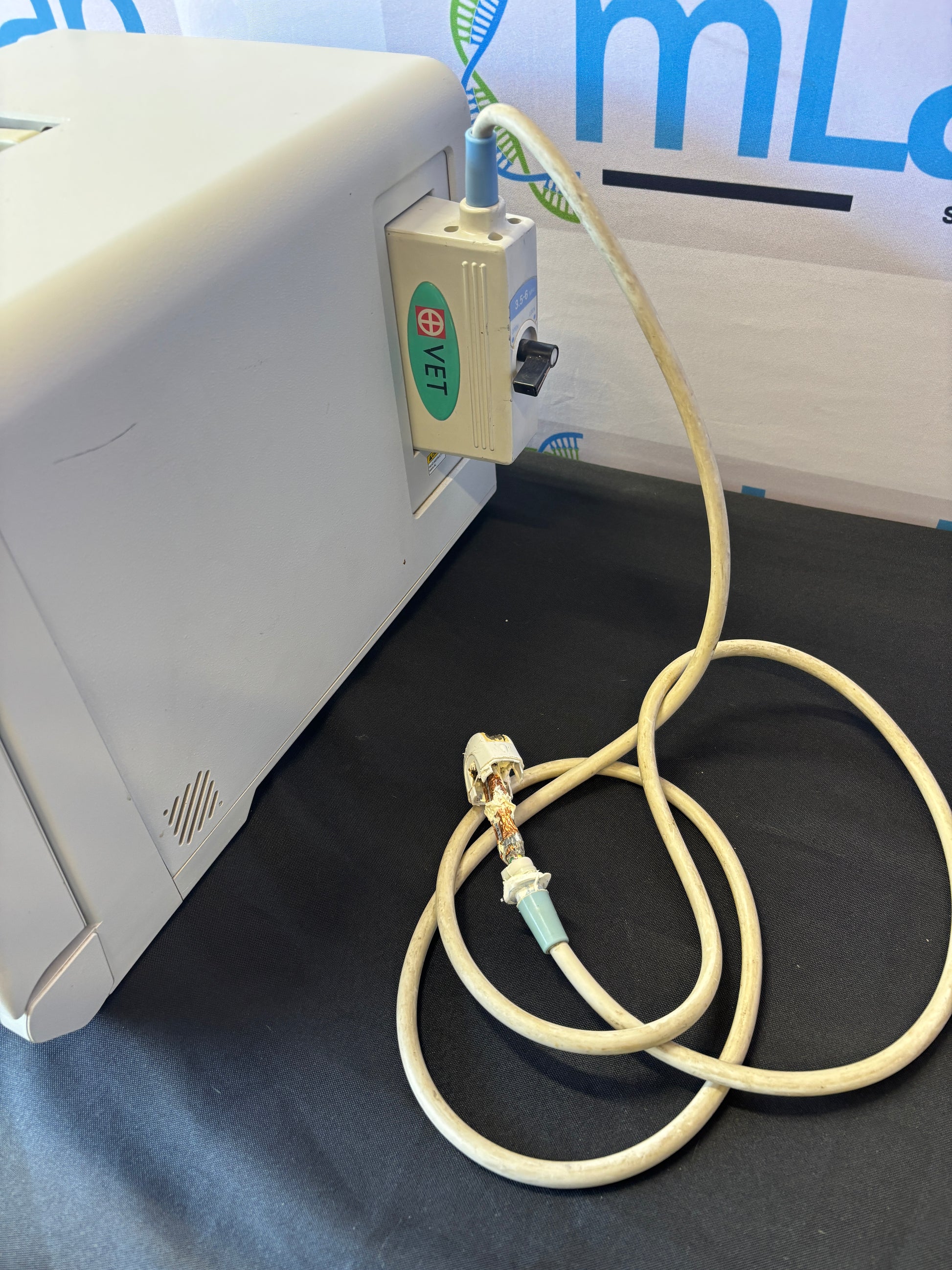 Medical device with a cable on a dark surface, featuring a brand logo.