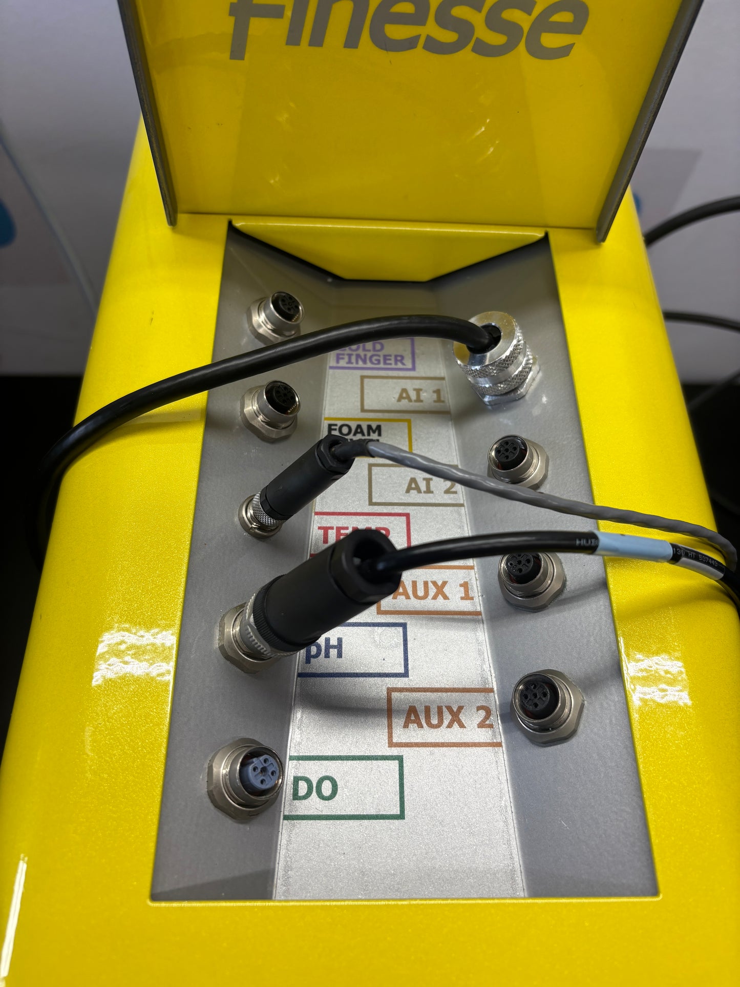 Yellow equipment with wiring and labels on a metallic panel
