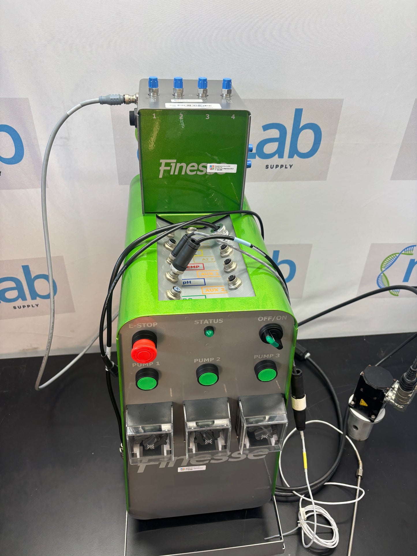 Green electronic device with wires on a white background with 'ab' branding.