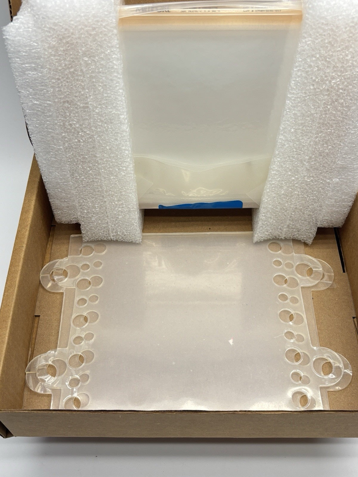 Lab Equipment available in San Diego biotech lab Box with bubble wrap and a decorative corner piece on a white surface