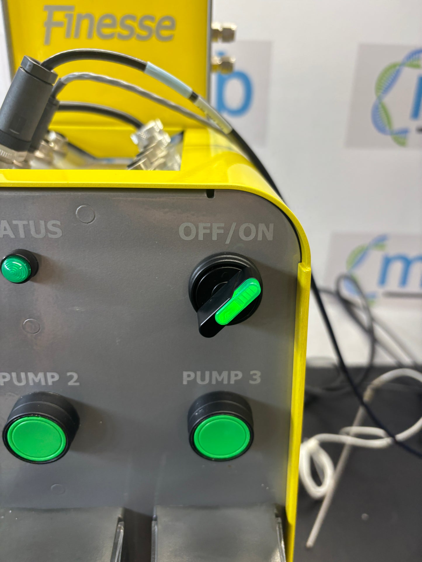 Control panel with green buttons on a machine, featuring the brand 'Finesse'.