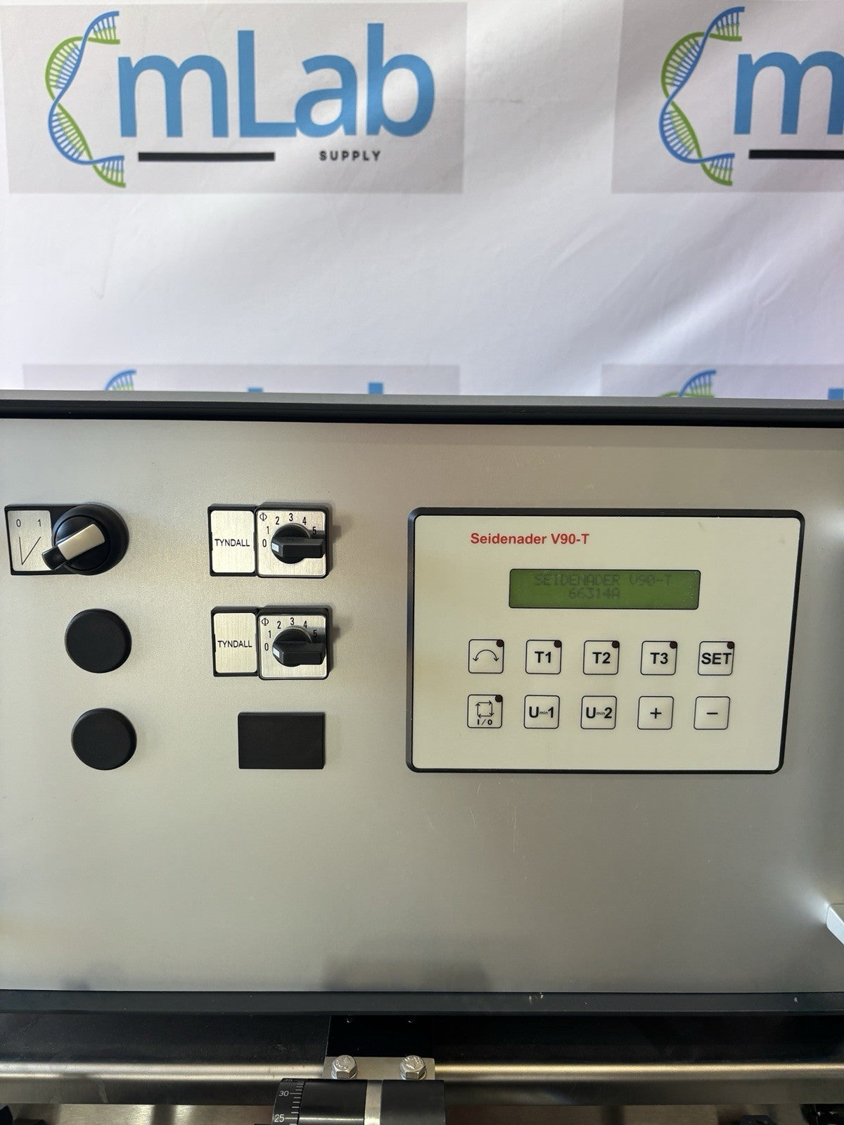 Control panel of a machine with 'mLab Supply' branding in the background