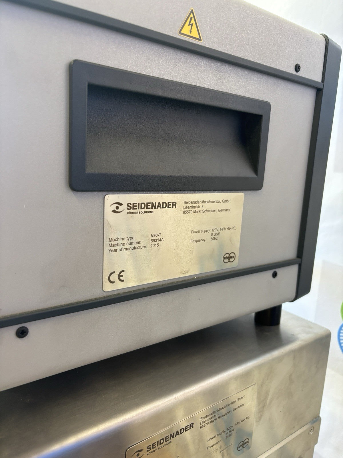 Seidenader machine with a warning label on a white background