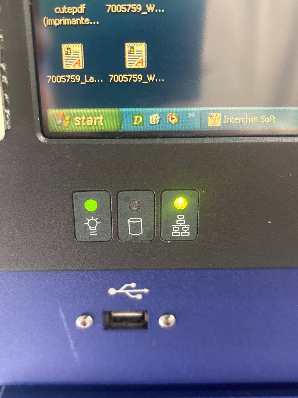 Close-up of a device with a screen displaying software interface and control buttons.